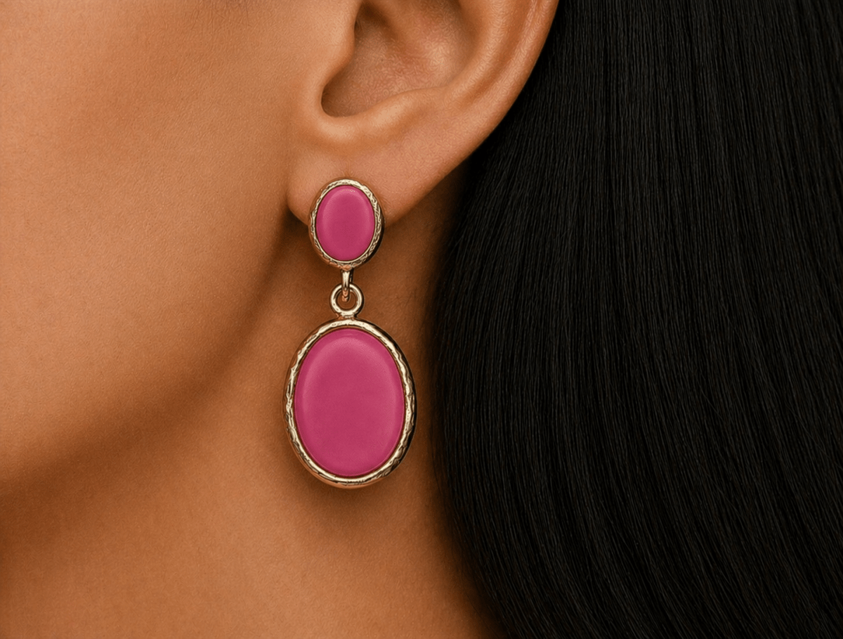 A model wearing some oval deep pink dangle drop earrings