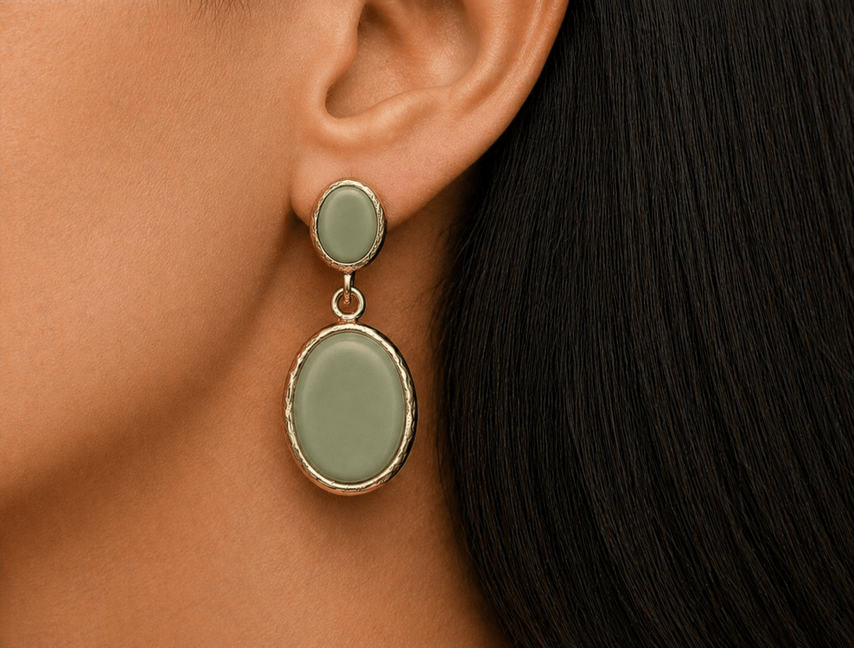 A model wearing some oval sage green dangle drop earrings