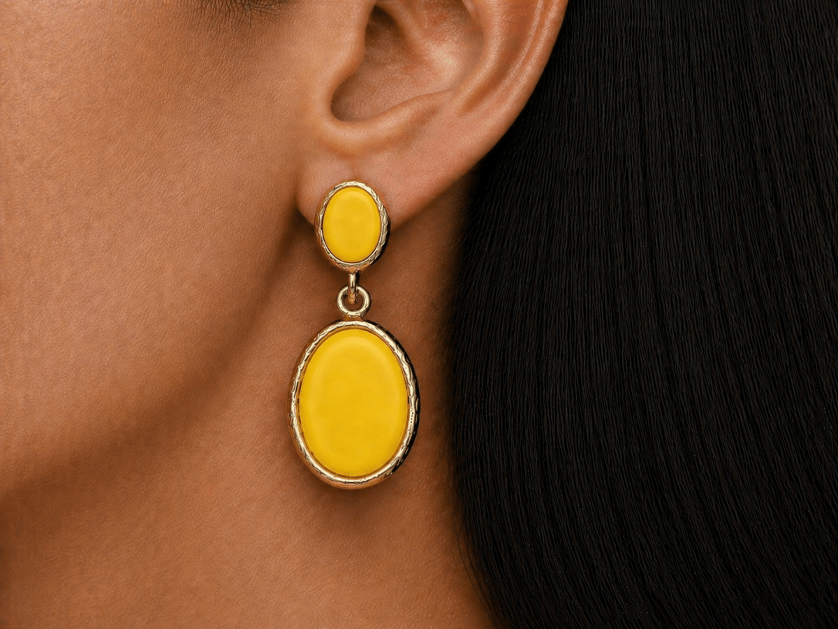 A model wearing some oval yellow dangle drop earrings