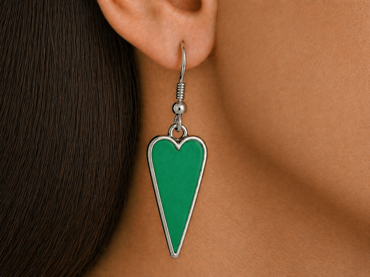 A model wearing some green heart shaped earrings