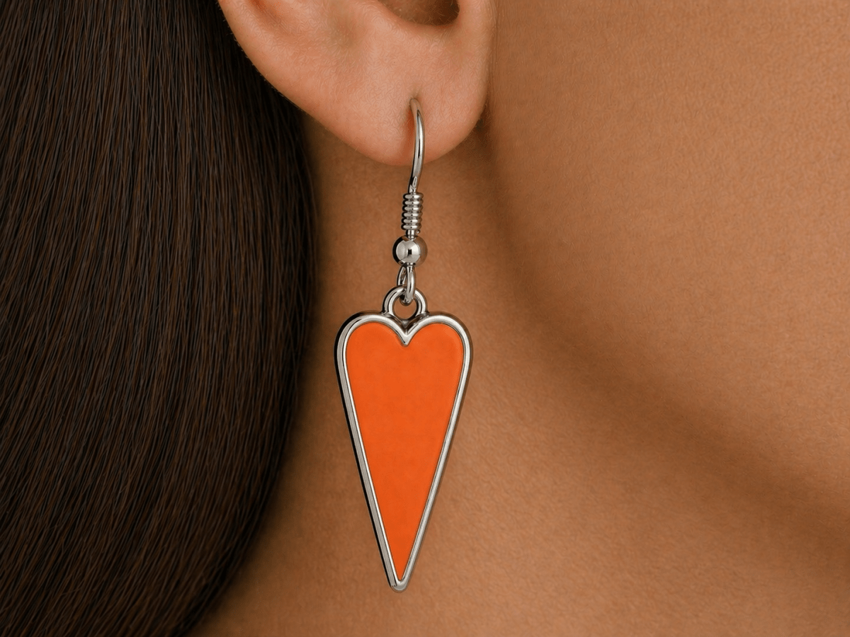 A model wearing some orange heart shaped earrings