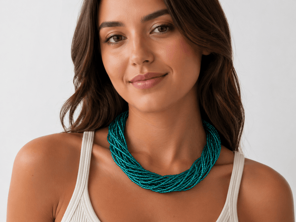 metallic teal multi strand seed bead necklace being worn by a model in a white top