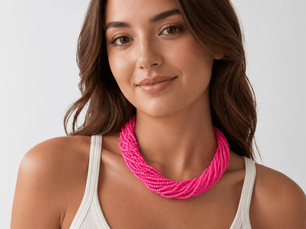  pink multi strand seed bead necklace being worn by a model in a white top