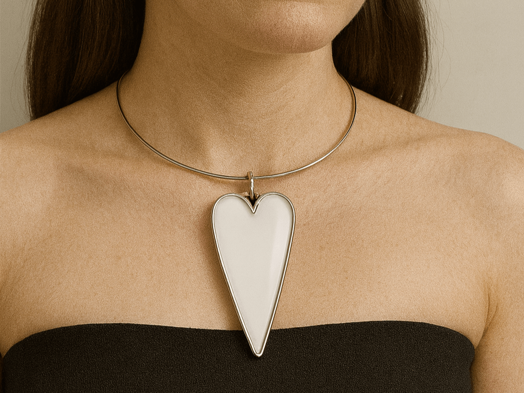 A model wearing a large white pendant with a black top