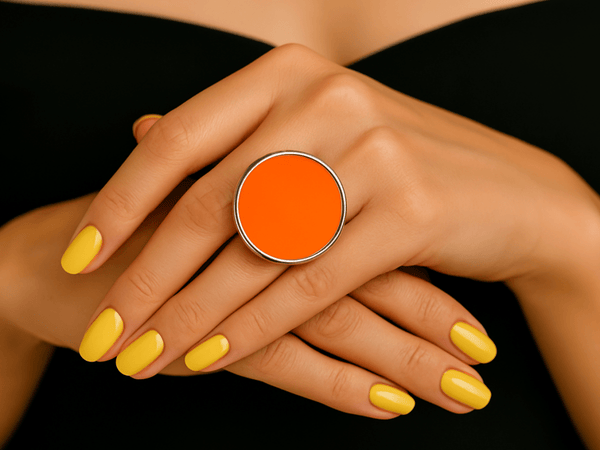  models hand wearing a bright neon orange round ring