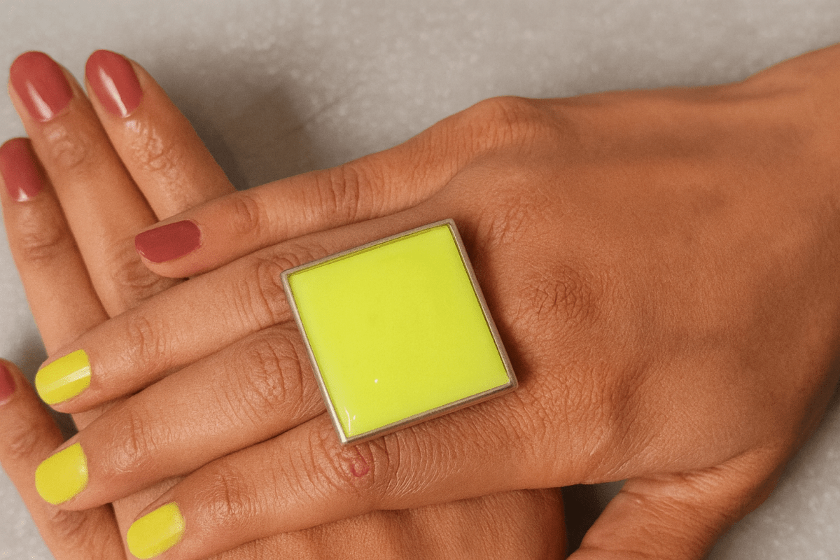  models hand wearing a bright neon yellow square ring