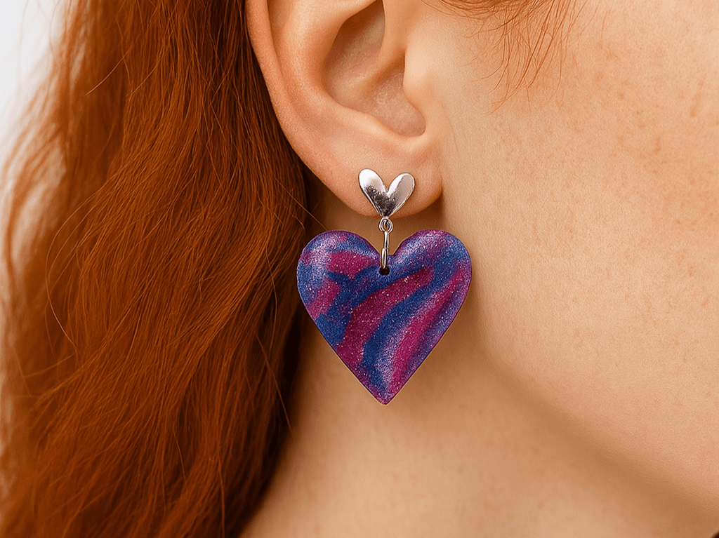Handmade unique clay heart earrings in vibrant colours of magenta purple and blue .Each earring features delicate silver heart detail and are lightweight and easy to wear - Corky & Stoner