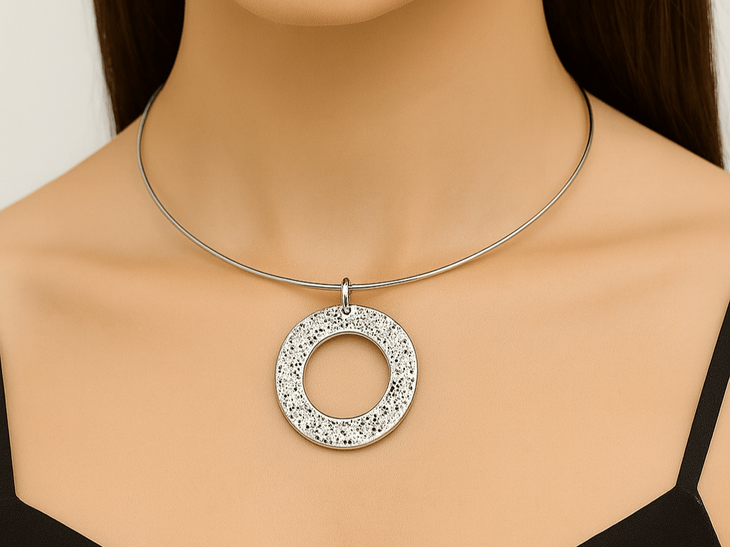 A model wearing a torque necklace with a circular silver pendant