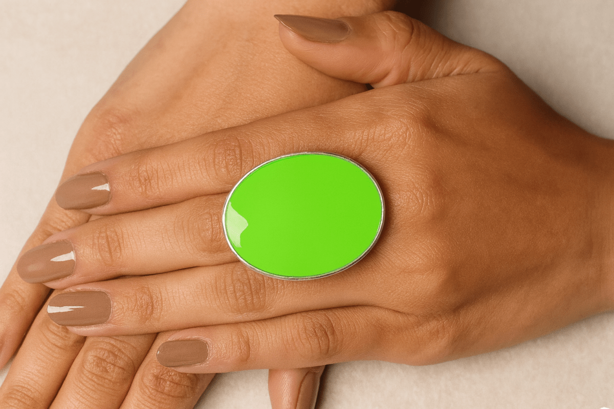 A models hands wearing a neon green oval ring
