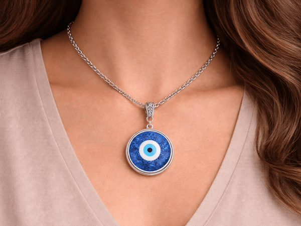 evil eye pendant necklace being worn by a model  in a white top