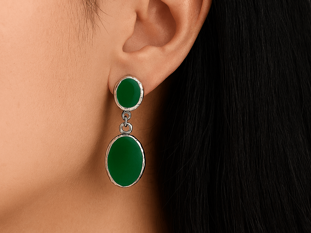 A model wearing some oval green dangle drop earrings