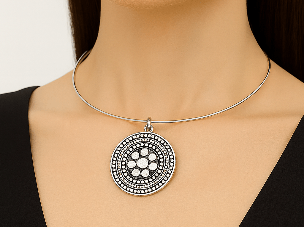 A model with a black top wearing a large silver choker