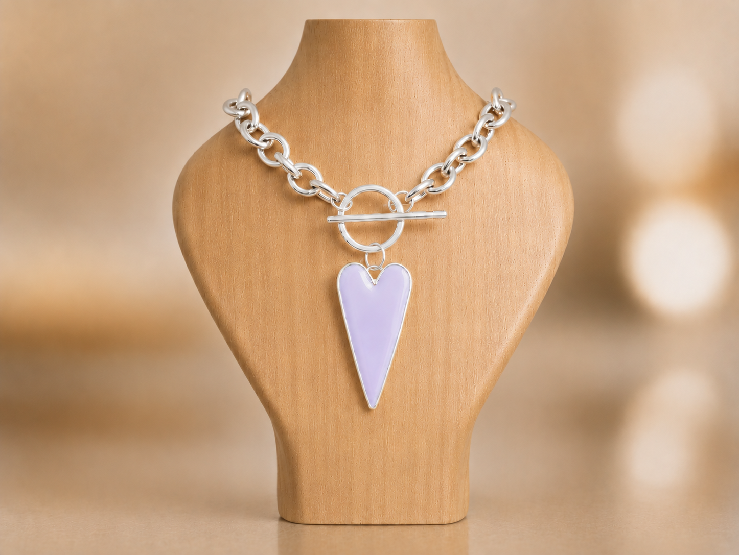 A large lilac colour pendant on a chunky stainless steel chain on a wooden bust Main image