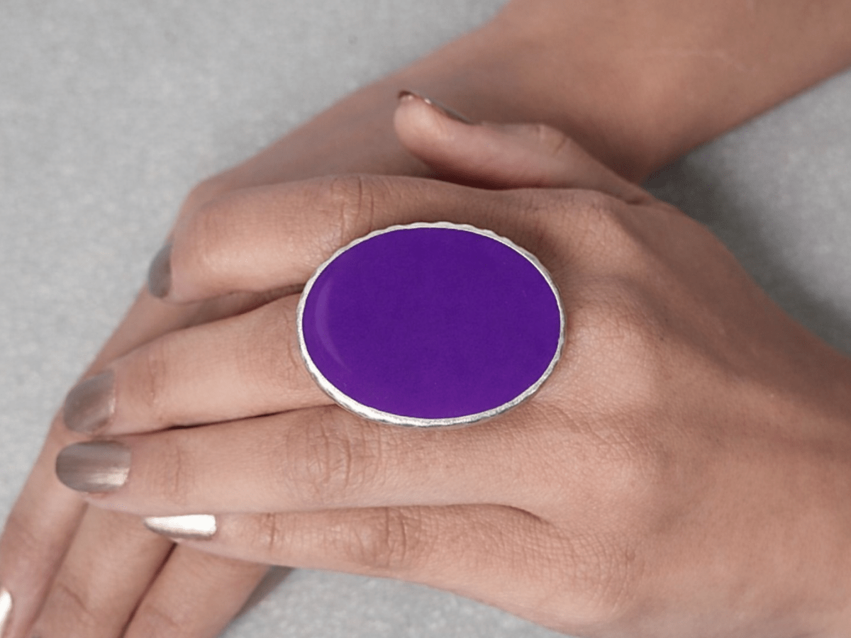 A models hand wearing a purple oval ring