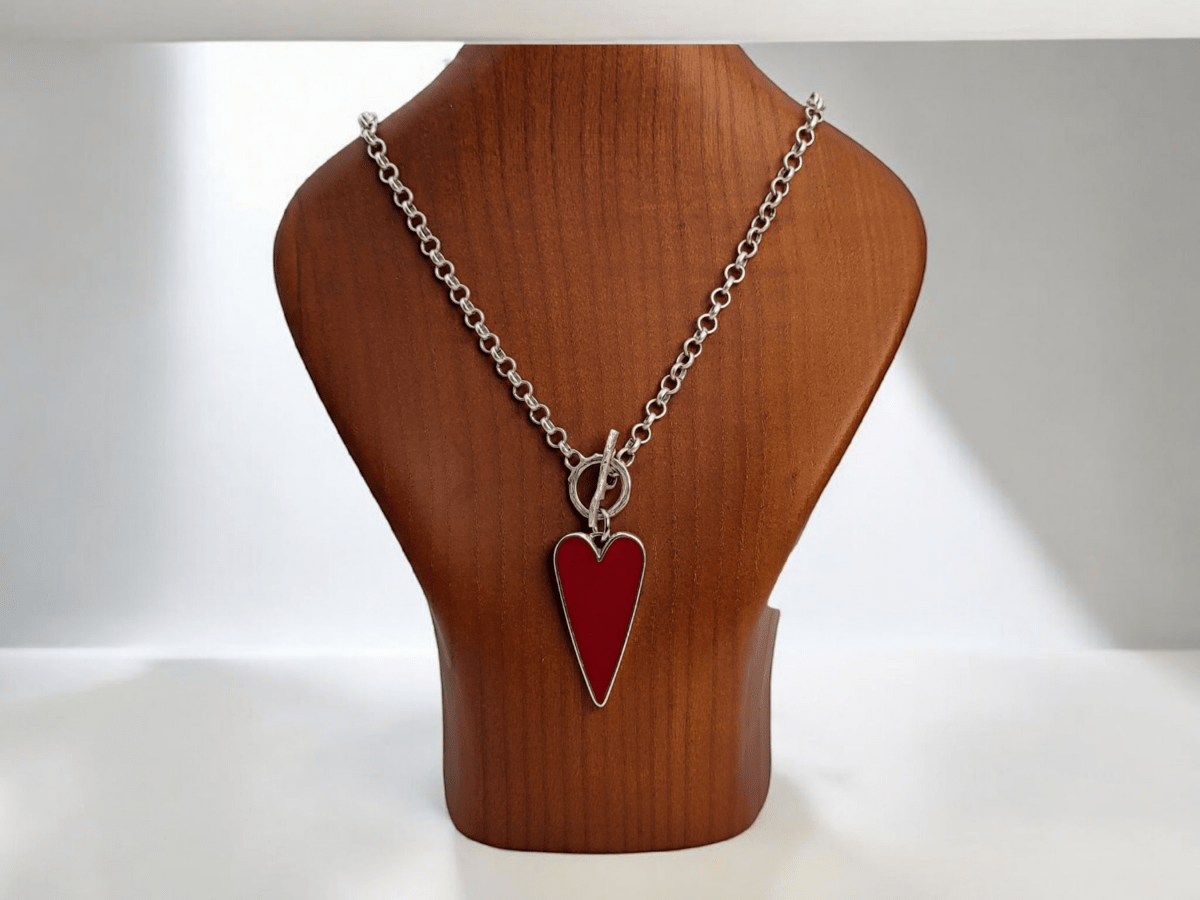 A red heart pendant on a wooden bust