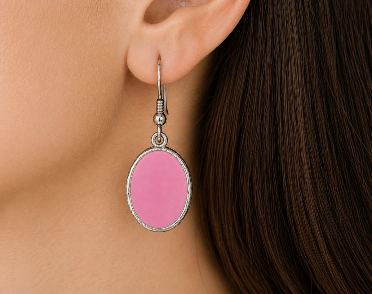 A model wearing some pale pink oval dangle drop earrings