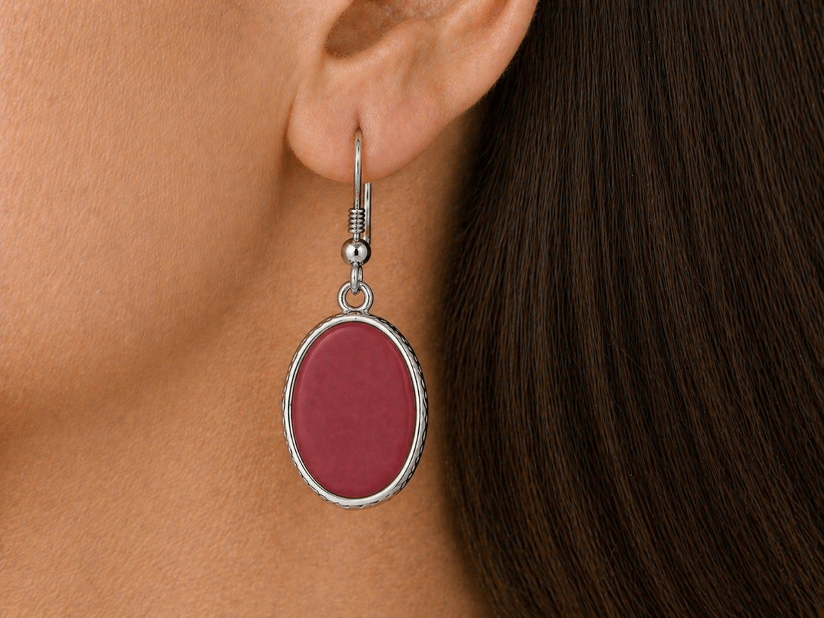 A model wearing some dark red oval dangle drop earrings