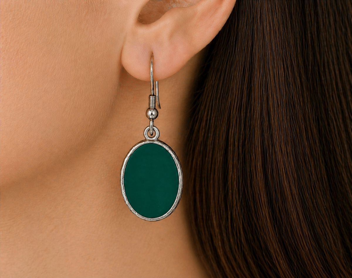 A model wearing some dark green oval dangle drop earrings