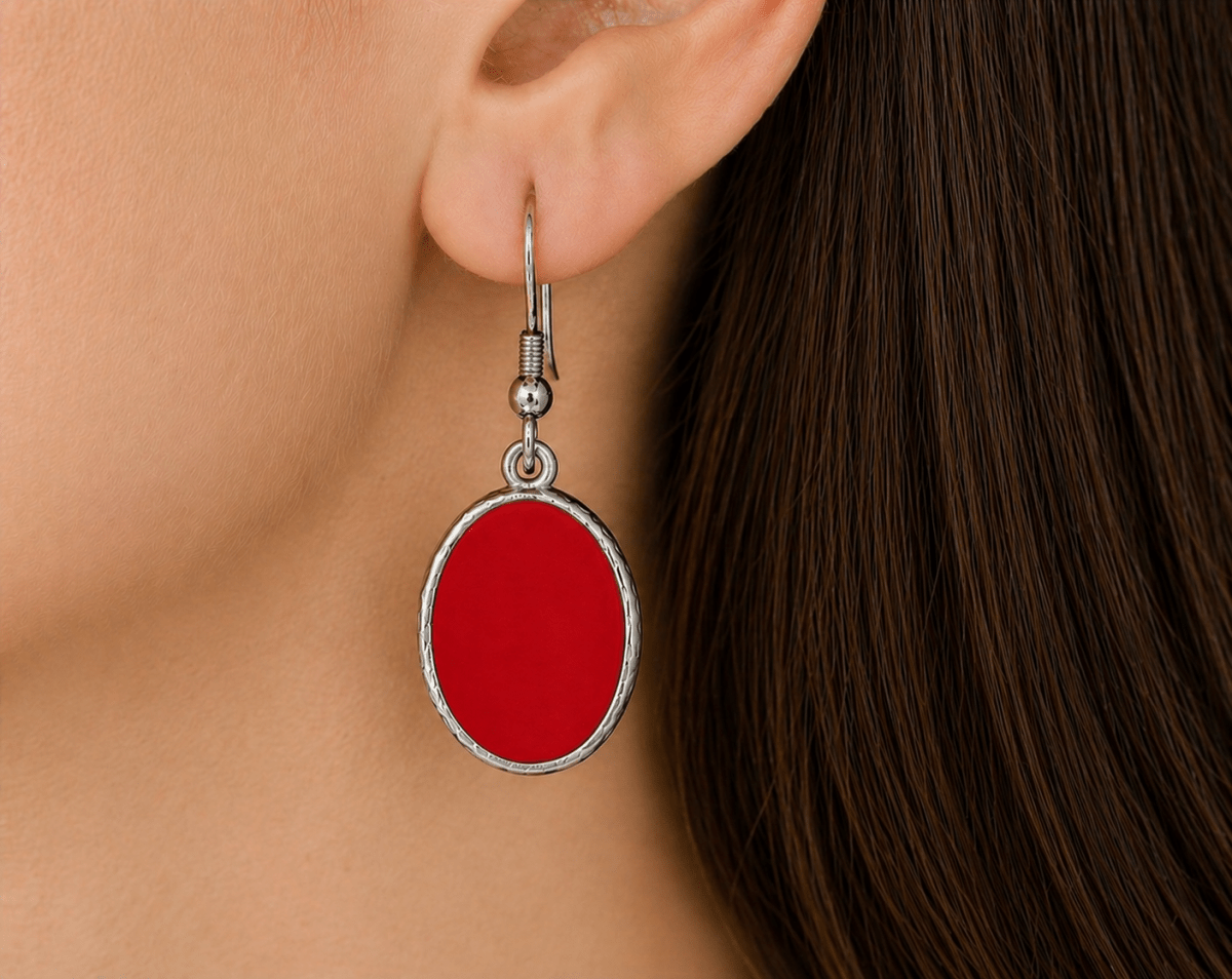 A model wearing some red oval dangle drop earrings