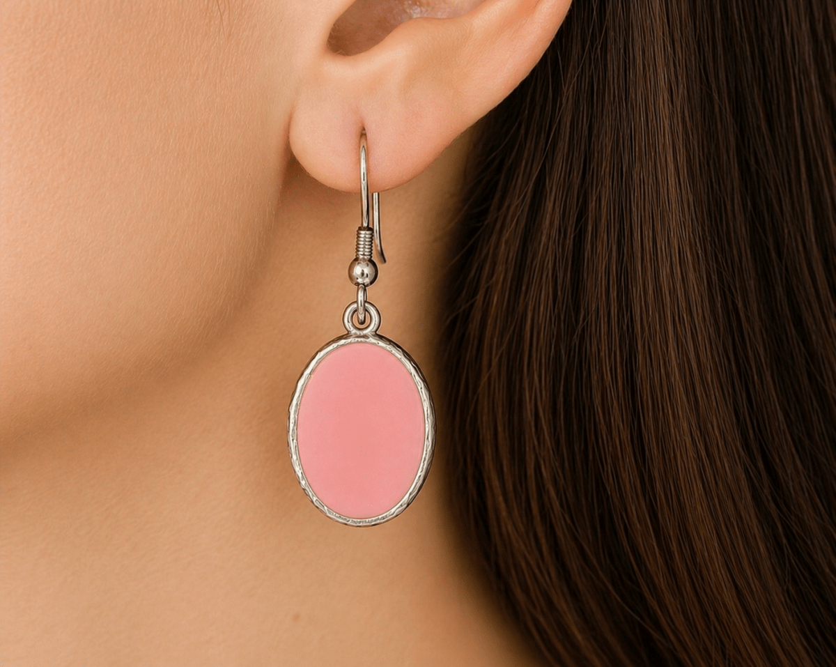 A model wearing some salmon pink oval dangle drop earrings