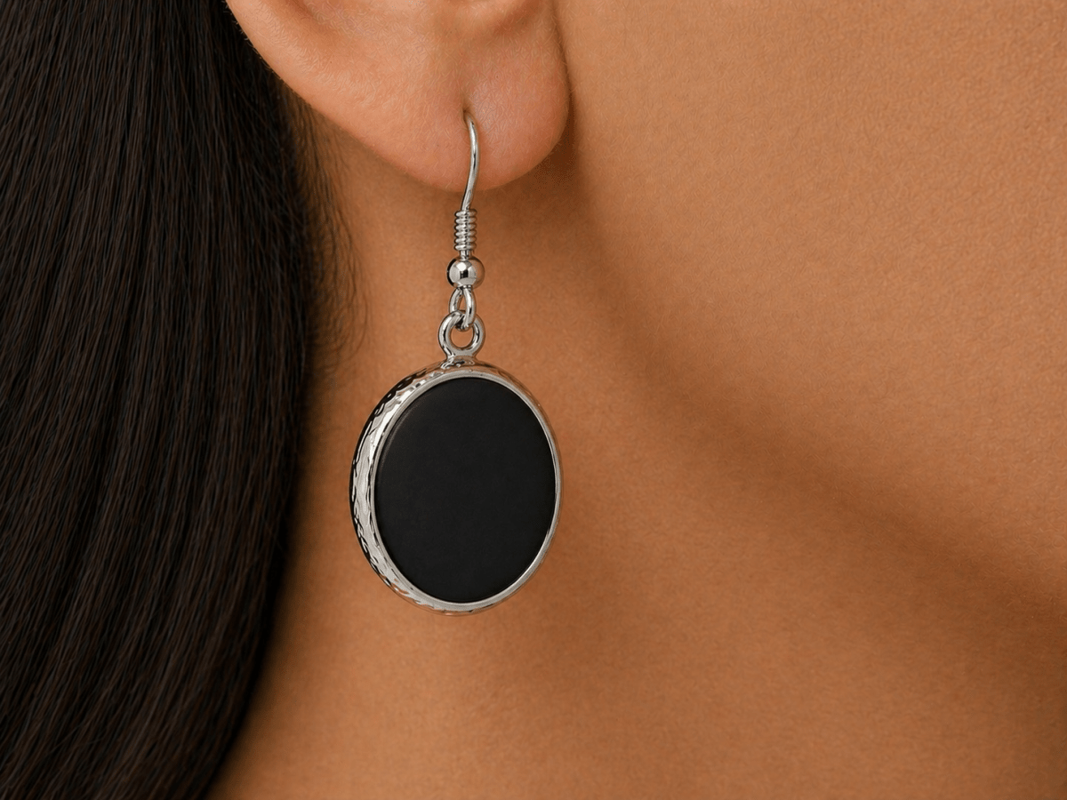 A model wearing some round black dangle drop earrings