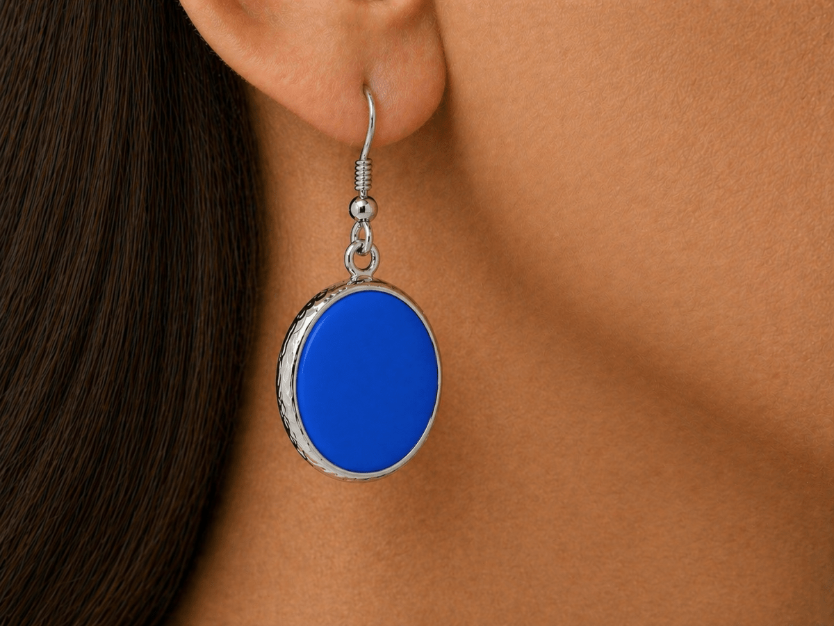 A model wearing some round blue dangle drop earrings