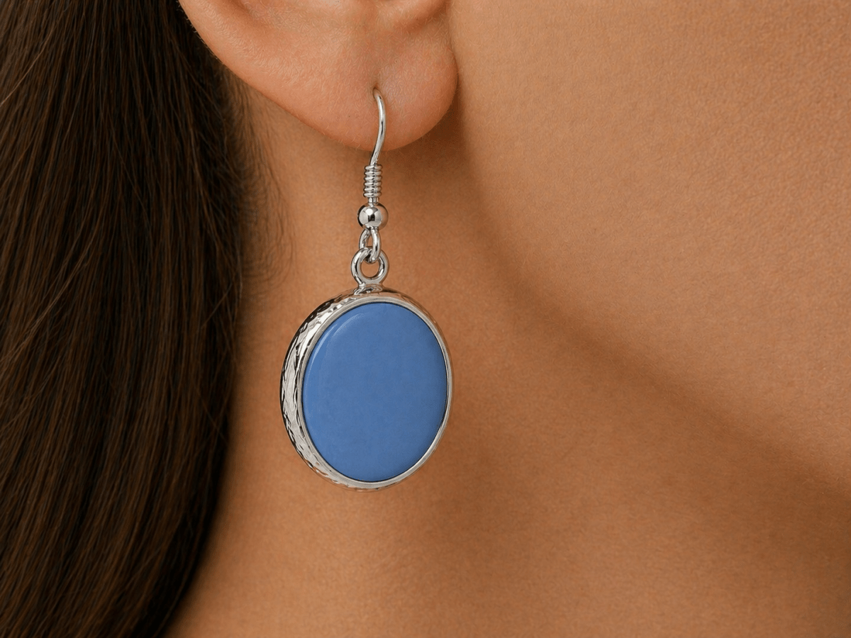 A model wearing some round blue dangle drop earrings