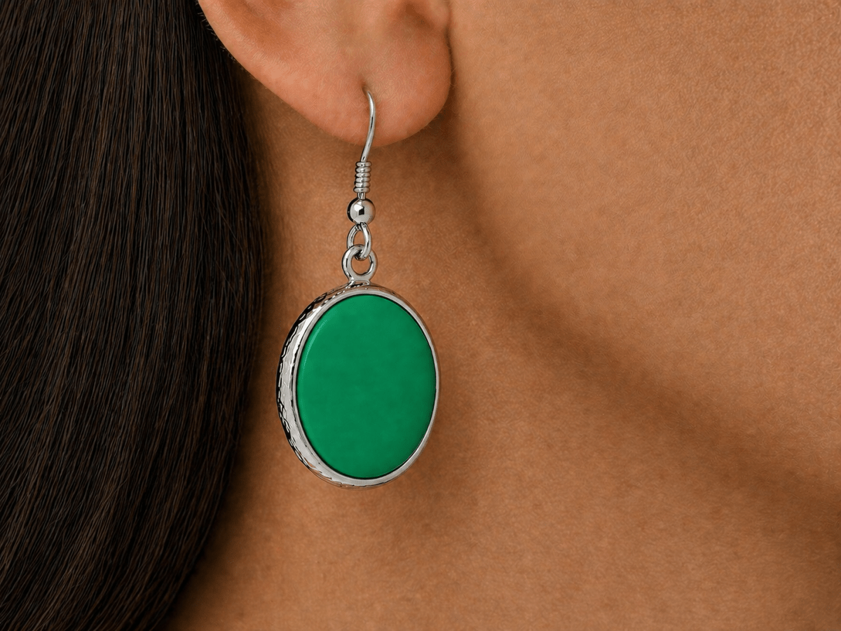 A model wearing some round green dangle drop earrings