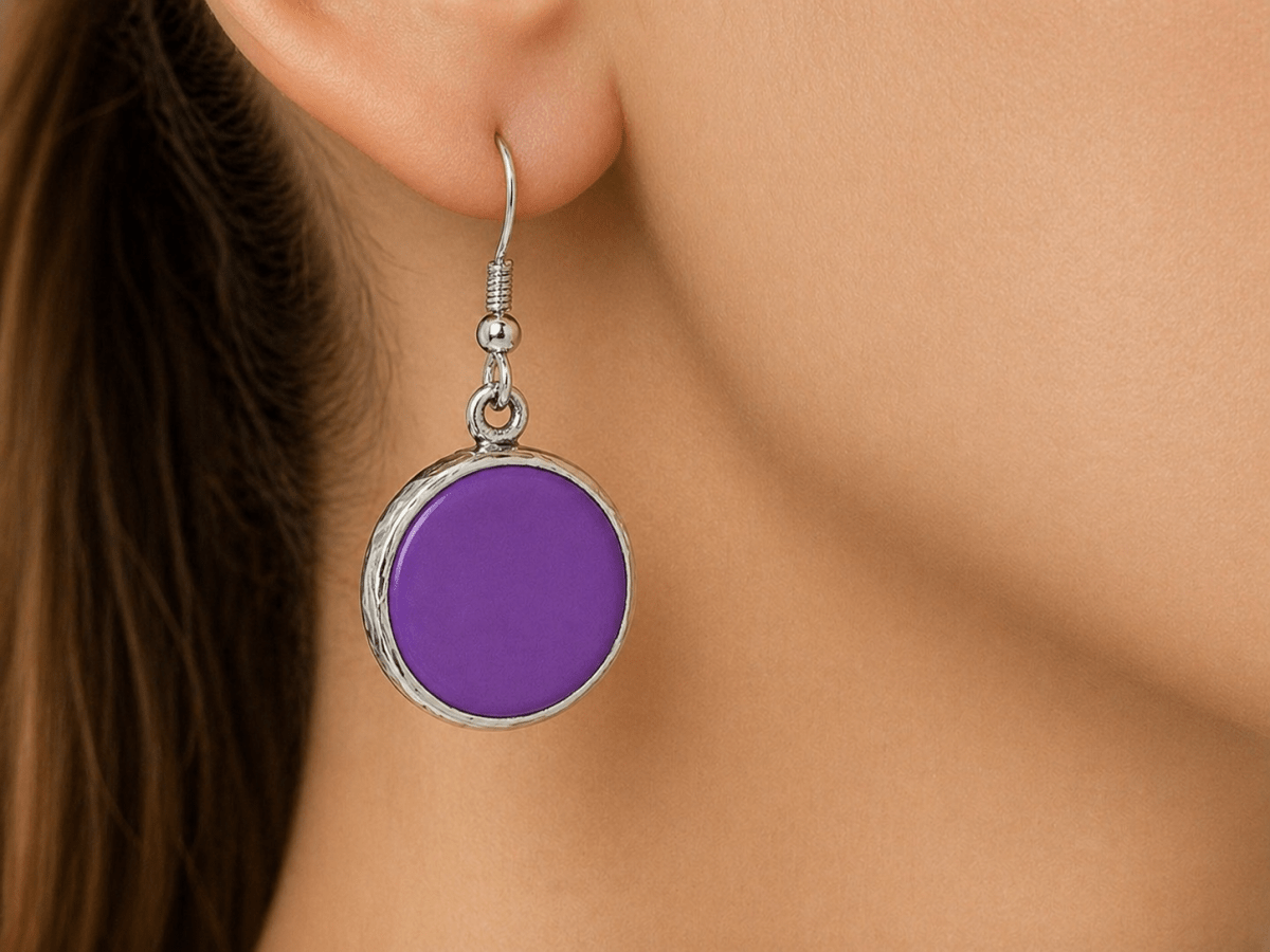 A model wearing some round purple dangle drop earrings