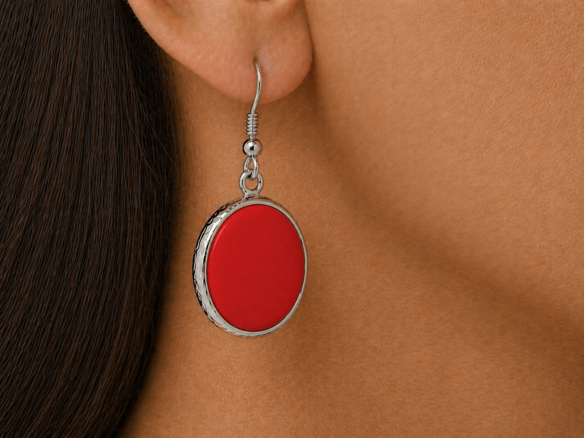 A model wearing some round red dangle drop earrings