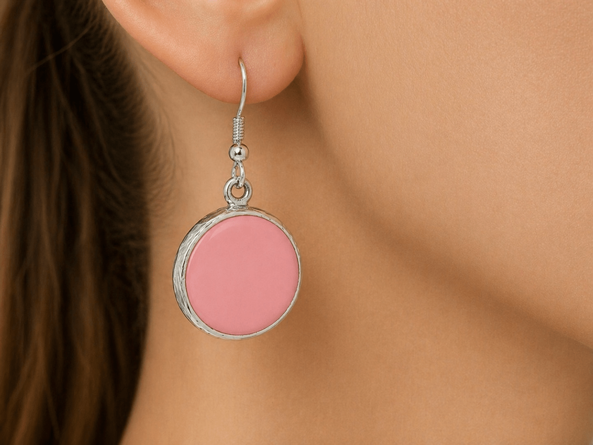 A model wearing some round pale pink dangle drop earrings