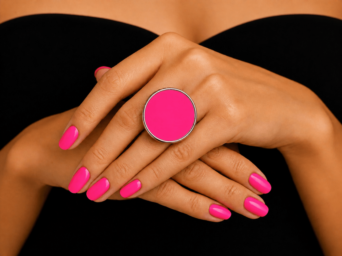  models hand wearing a bright neon pink round ring