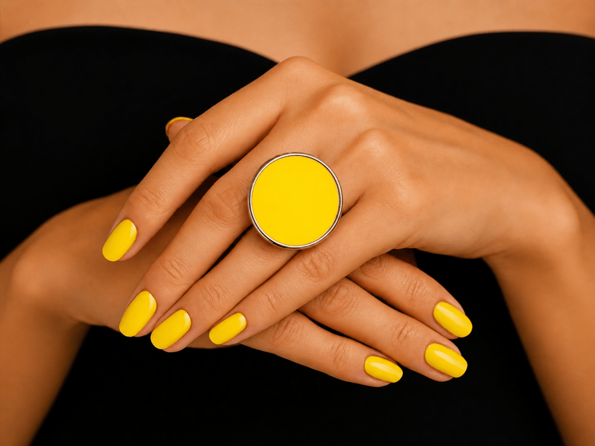  models hand wearing a bright neon yellow round ring