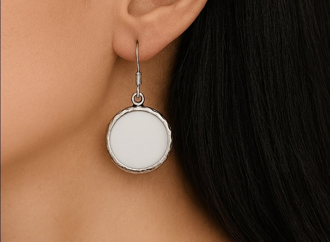 A model wearing some round white dangle drop earrings
