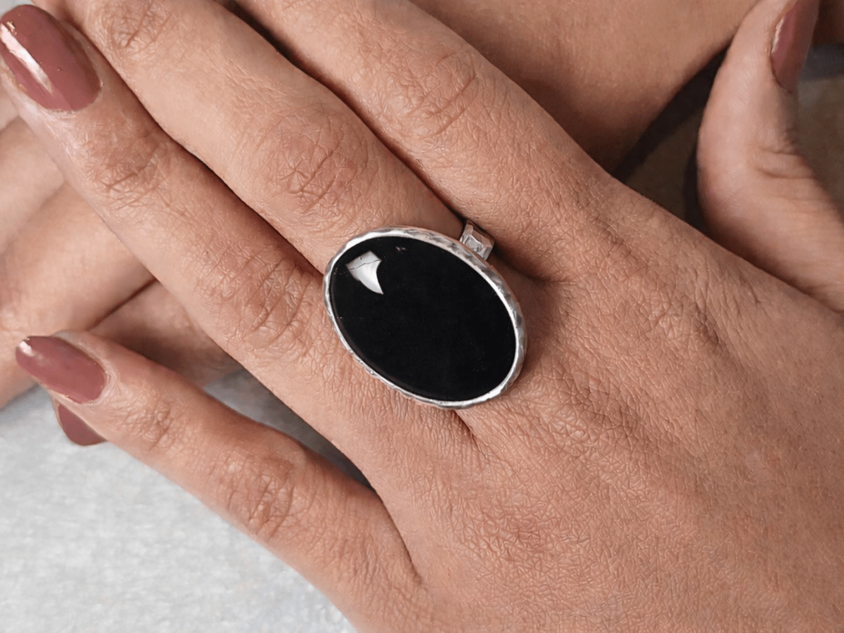 A models hands wearing a black ring