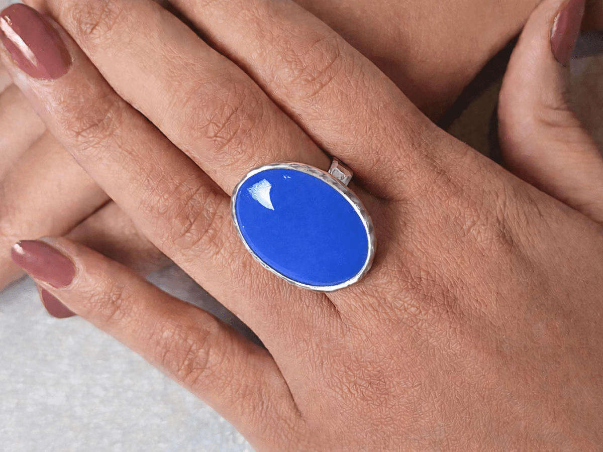 A models hands wearing a bright blue ring