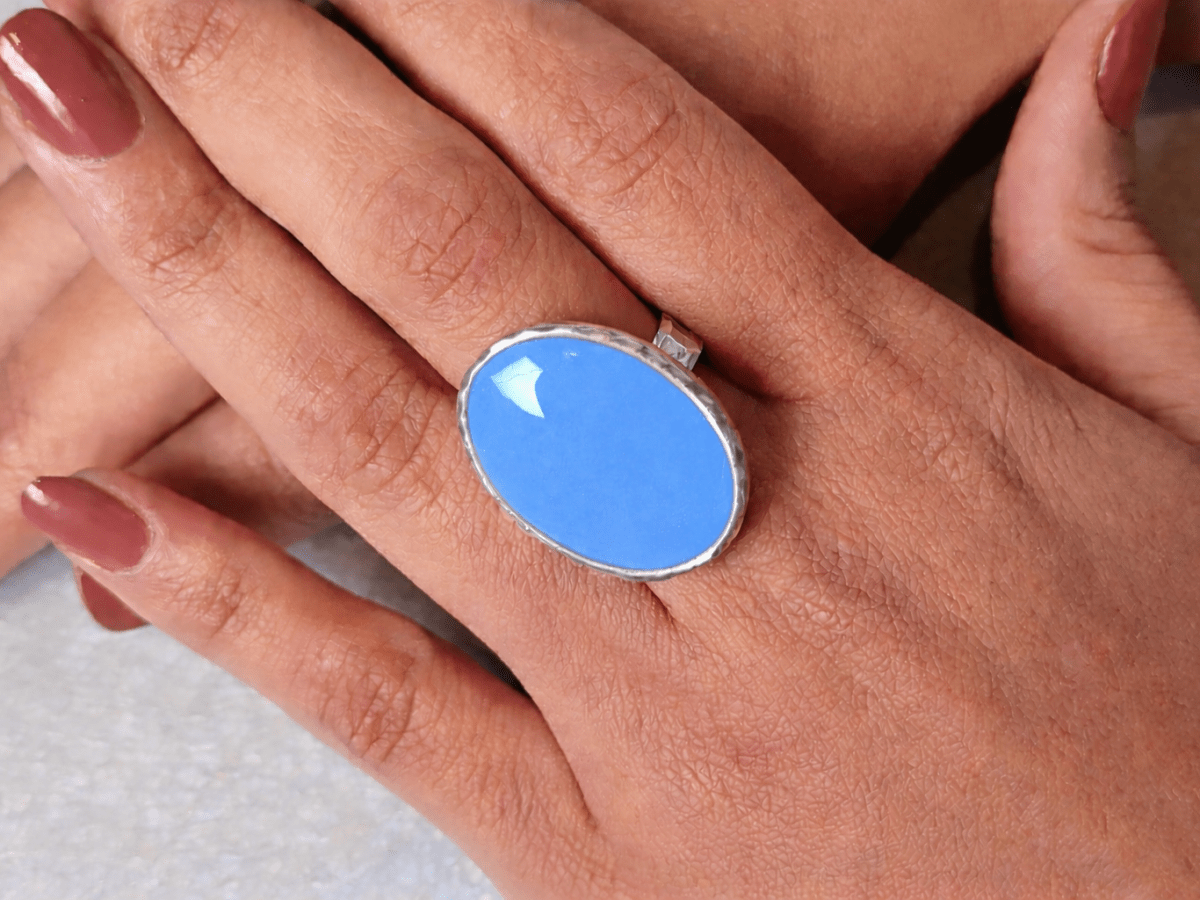A models hands wearing a pale blue ring