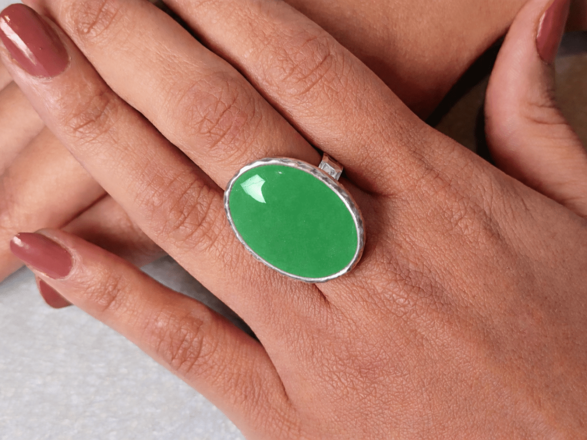 A models hands wearing a green ring