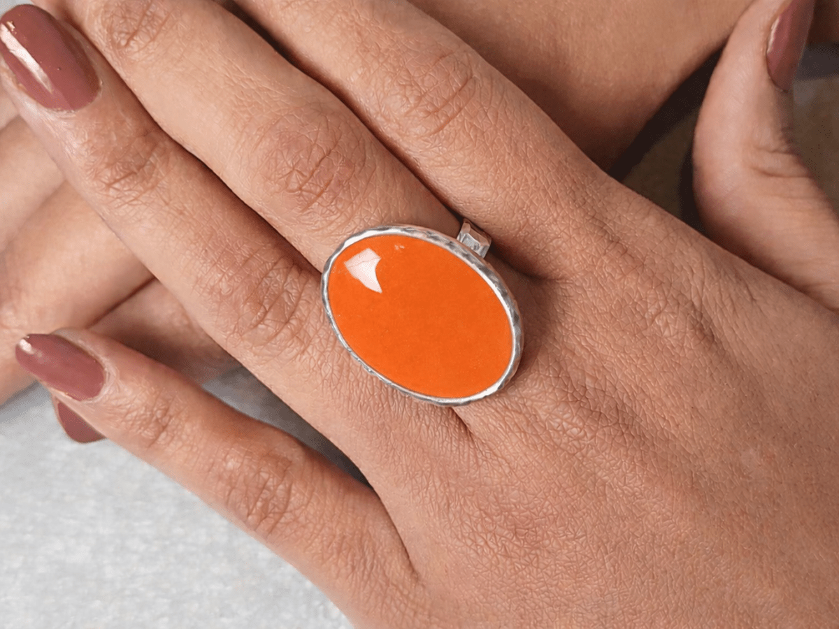 A models hands wearing an orange ring