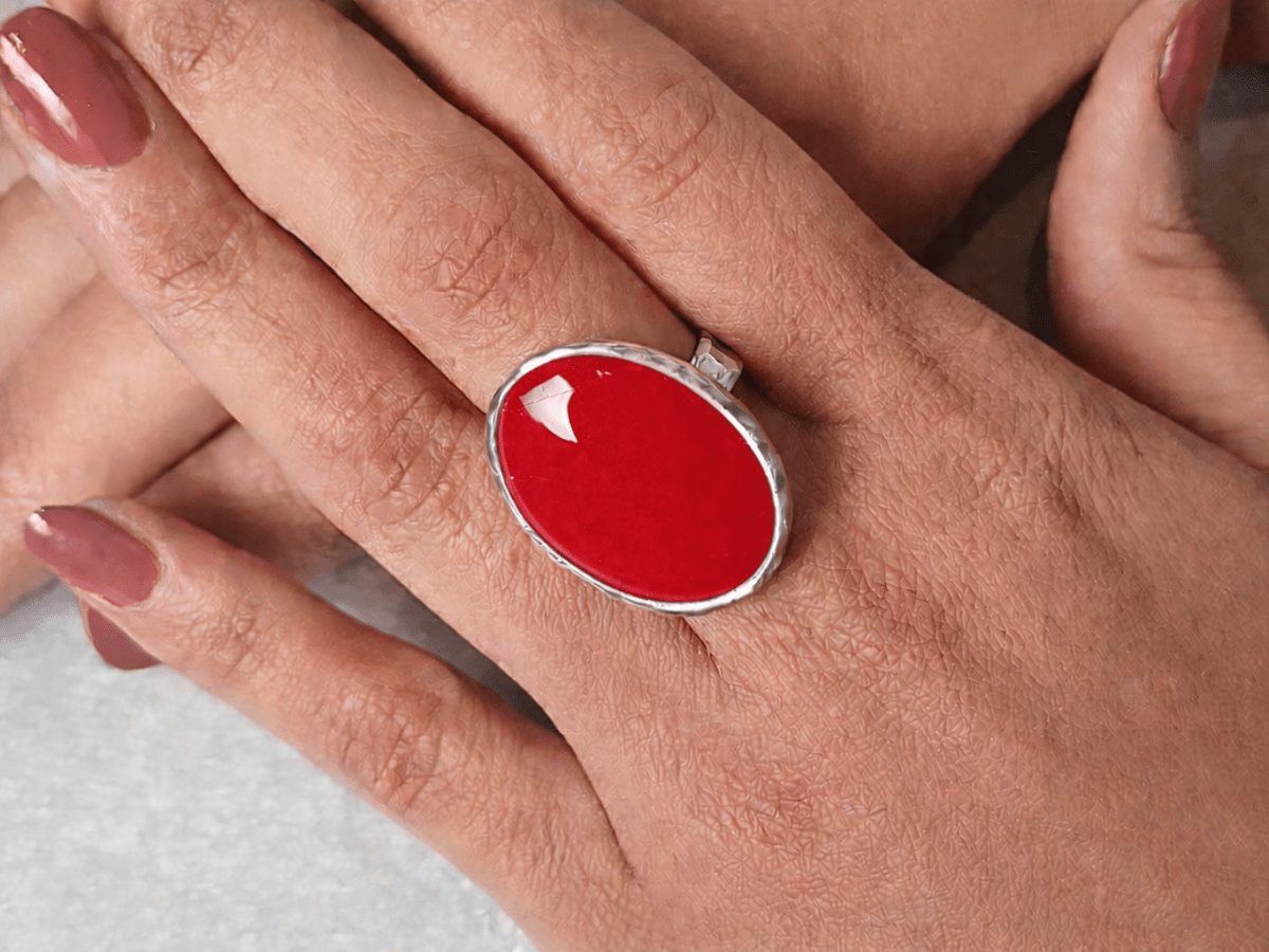 A models hands wearing a red ring