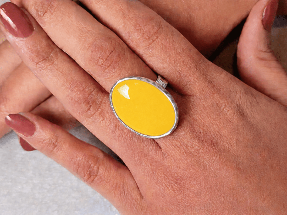 A models hands wearing a yellow ring