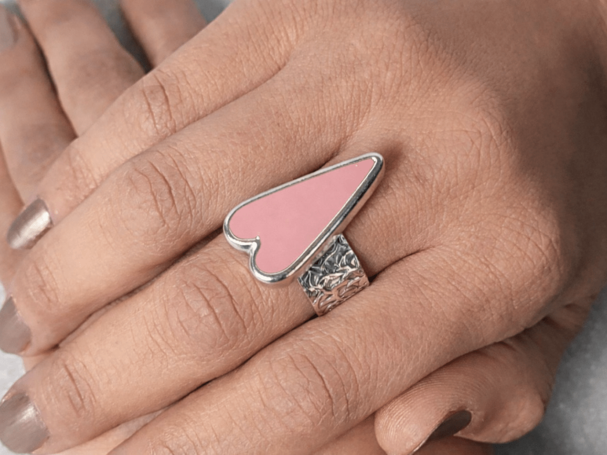 A models hands wearing a pink heart ring