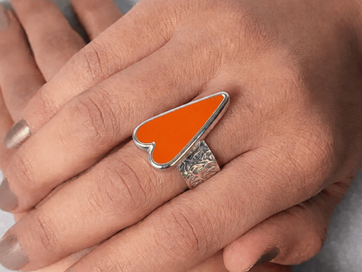 A models hands wearing an orange heart ring