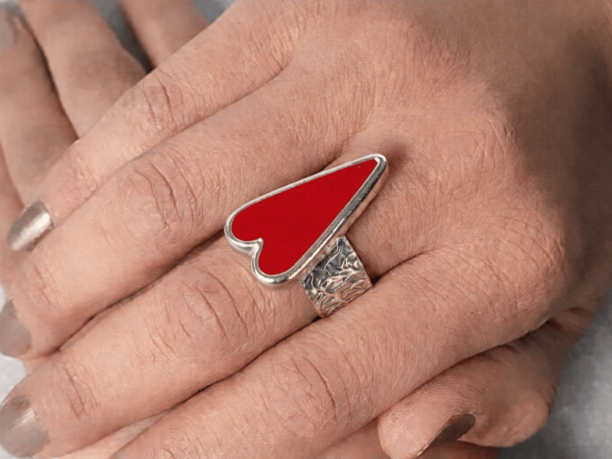 A models hands wearing a red heart ring