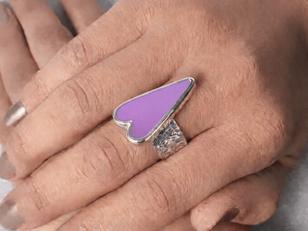 A models hands wearing a violet  heart ring