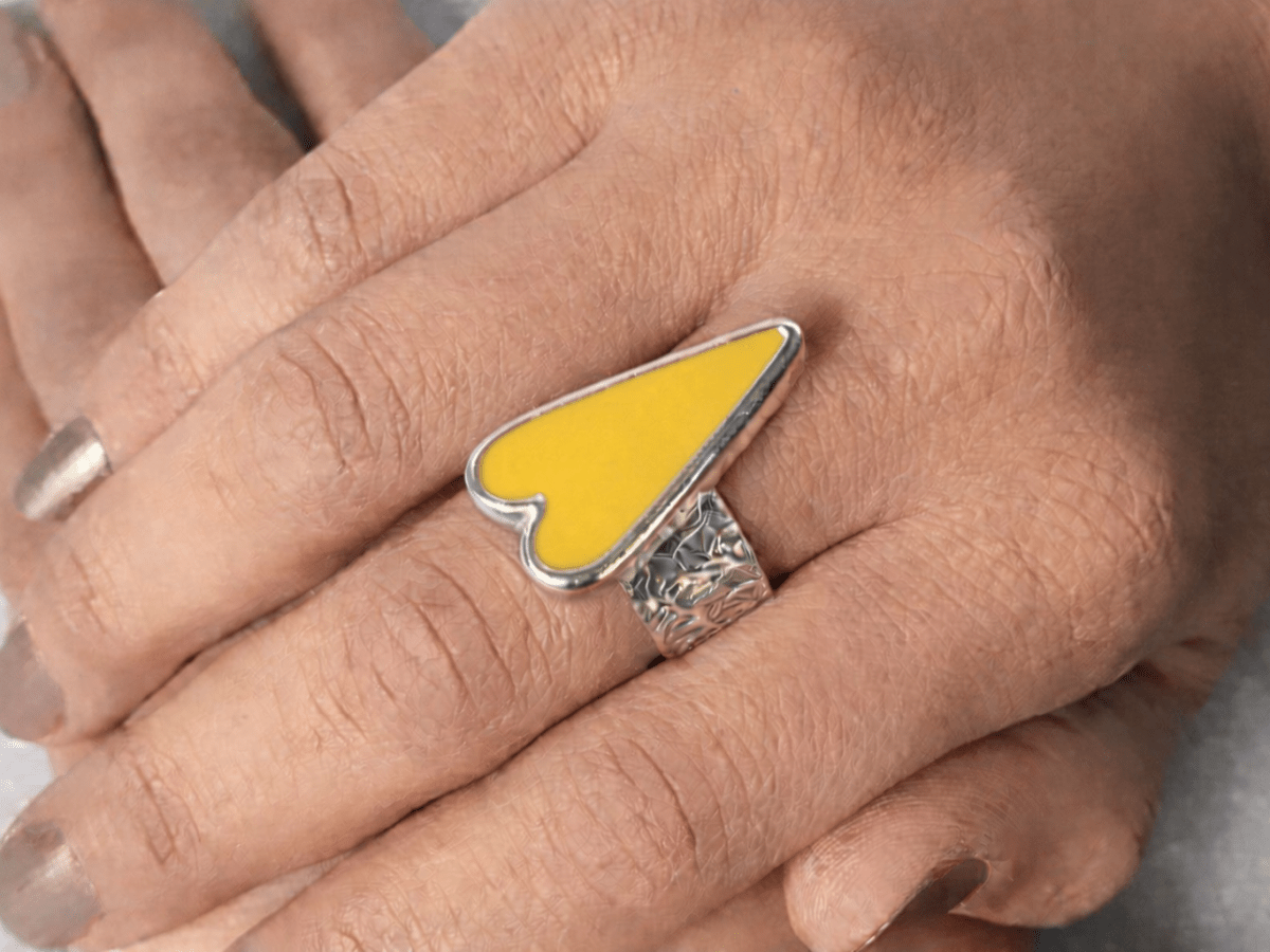 A models hands wearing a yellow heart ring
