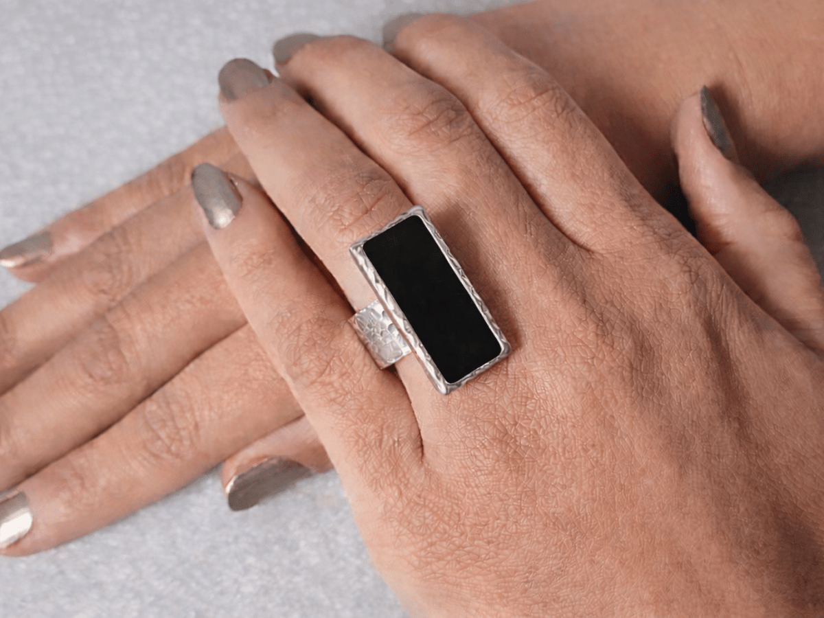 A models hand wearing a rectangular black ring