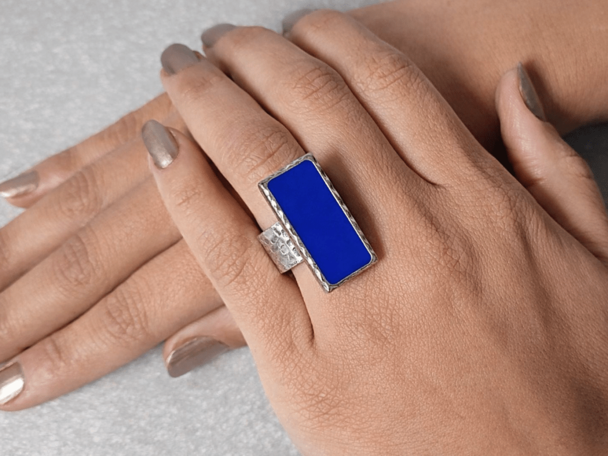 A models hand wearing a rectangular royal blue ring