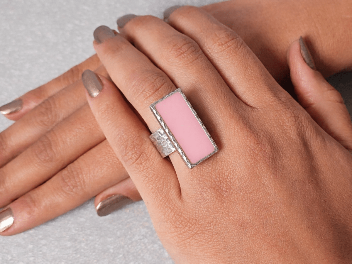 A models hand wearing a rectangular pink ring
