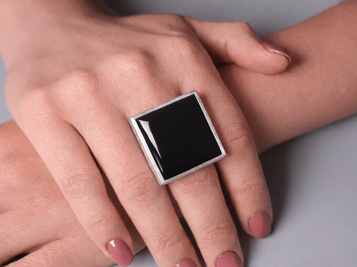 Models hands wearing a square black ring